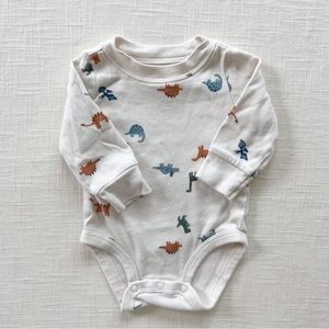 Carters baby boy long sleeve onesie in beige and orange dinosaur print.